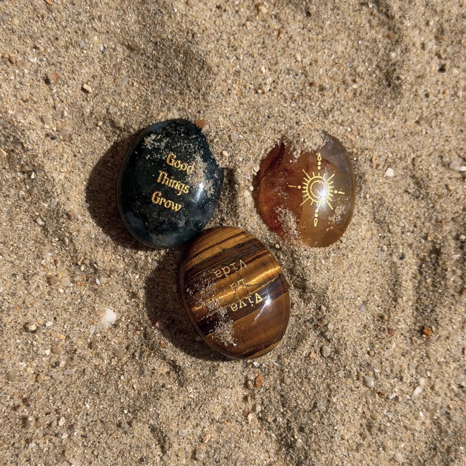 Begin Again three-stone set photographed on sand